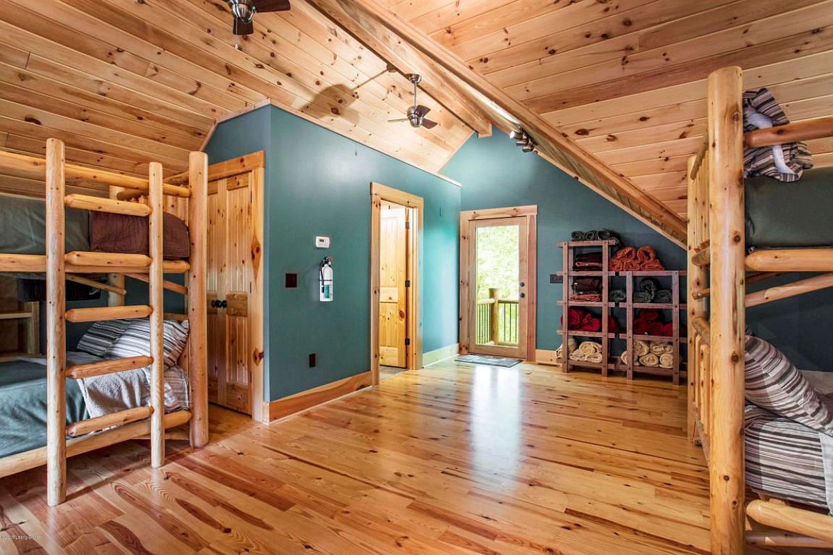 light teal walls in upstairs log cabin bedroom with two doors in corner of room
