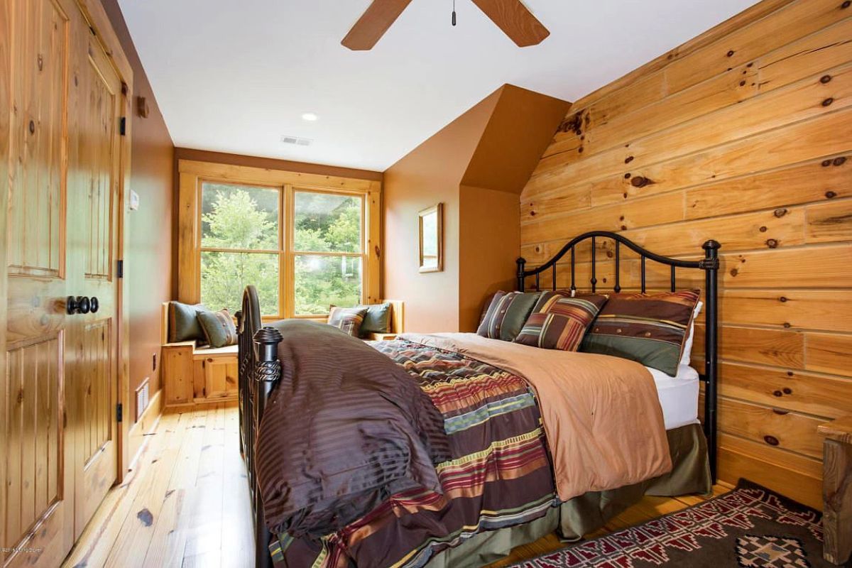 iron bed frame against wall with bench window seat in background