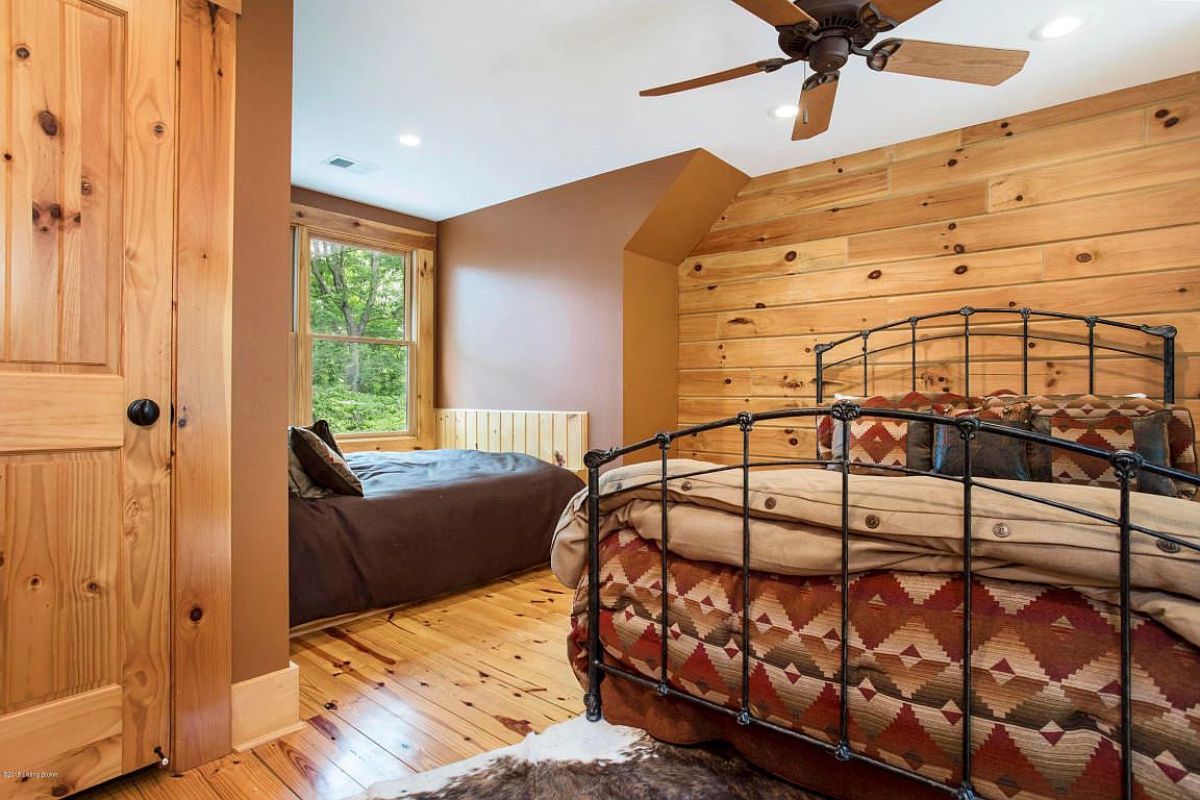 gray bedding on bed by window with iron bedframe on bed in foreground