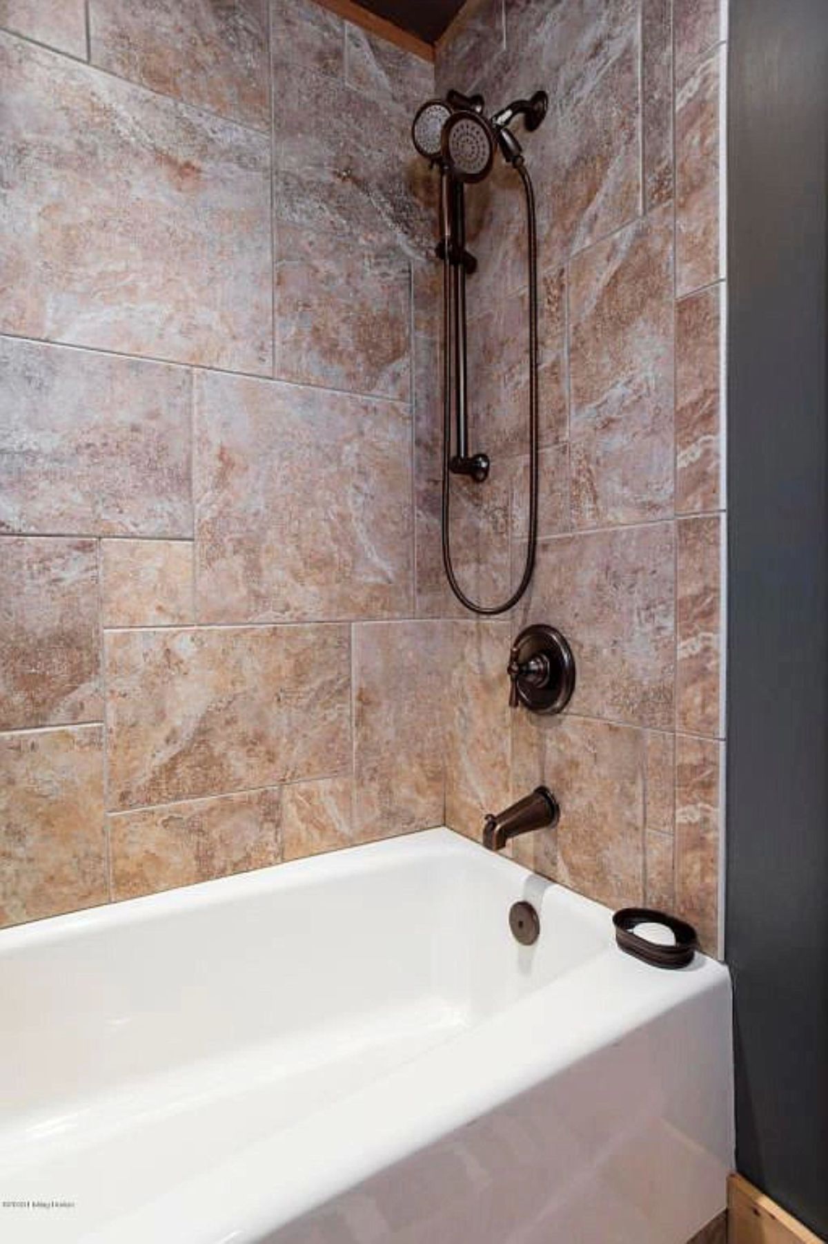 light pink marble tile above white bathtub