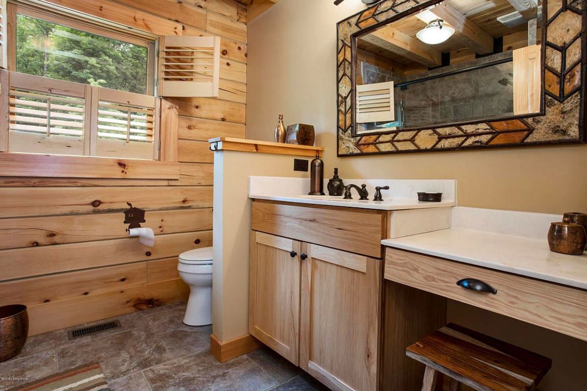 light wood walls with white wall separating wood sink and cabinet from white toilet