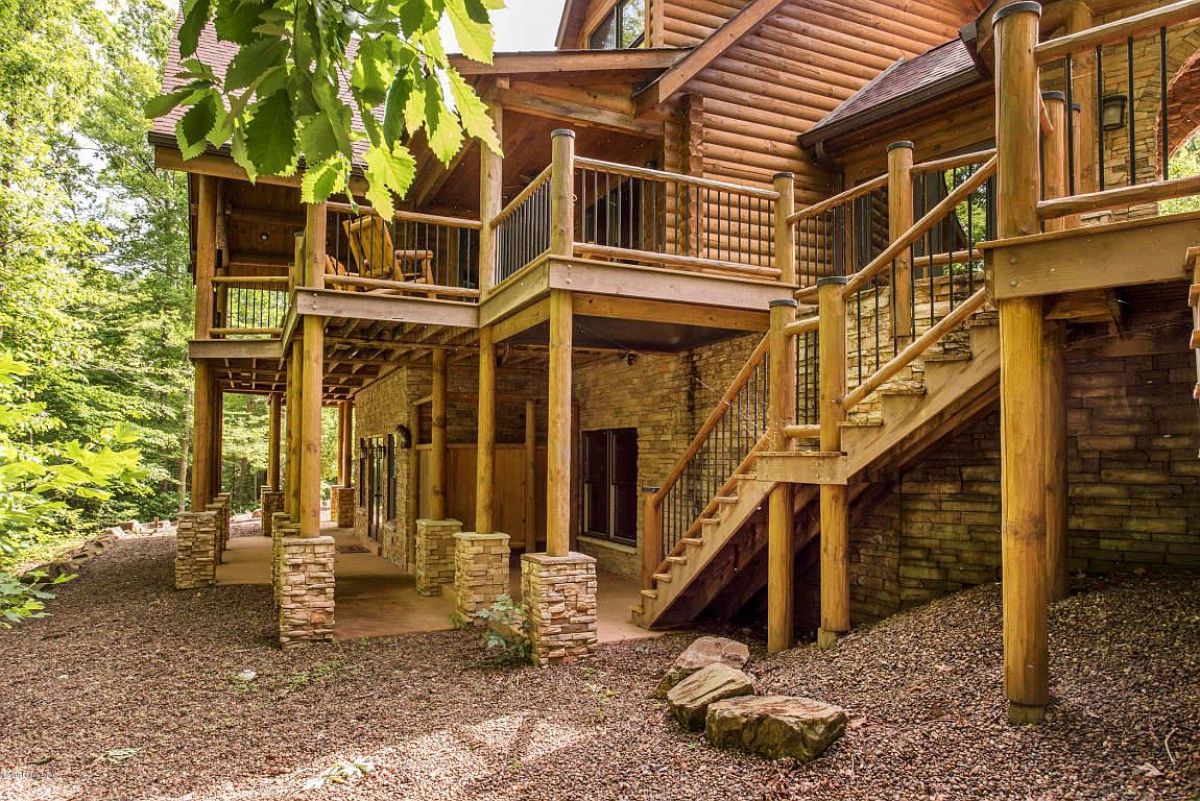 decks and stairs on back of log cabin with stone column foundation