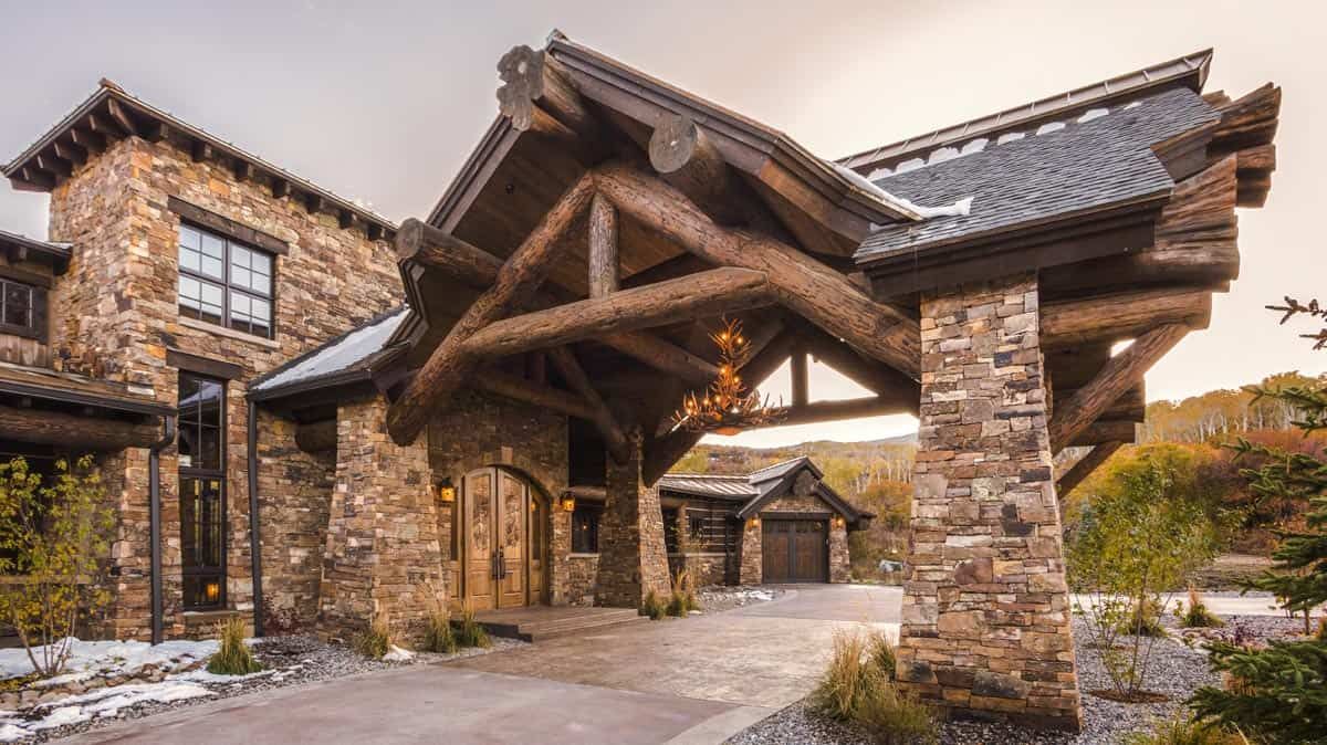 stone columns on front of log cabin with wood accents