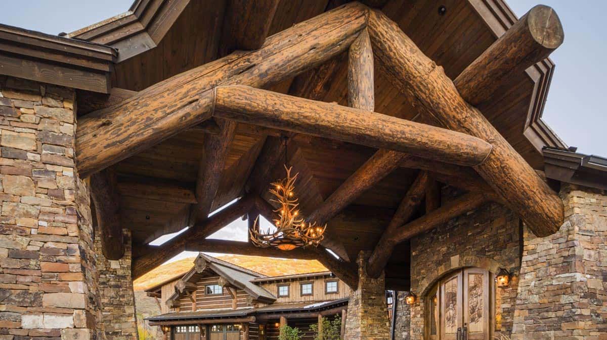 wood accents on top of awning with stone around edge of home