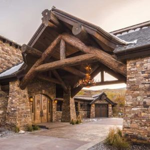stone columns on front of log cabin with wood accents