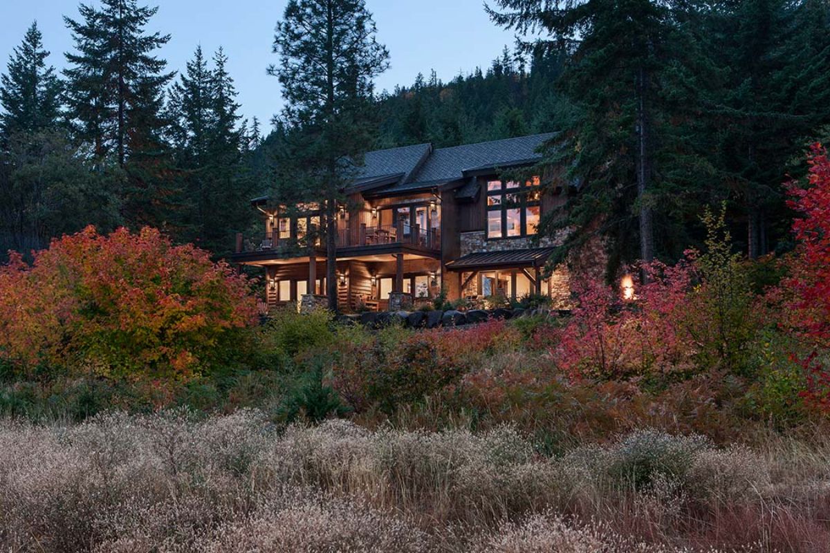 log cabin on hill behind orange shrubs