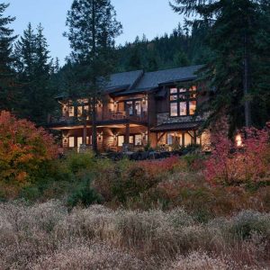 log cabin on hill behind orange shrubs