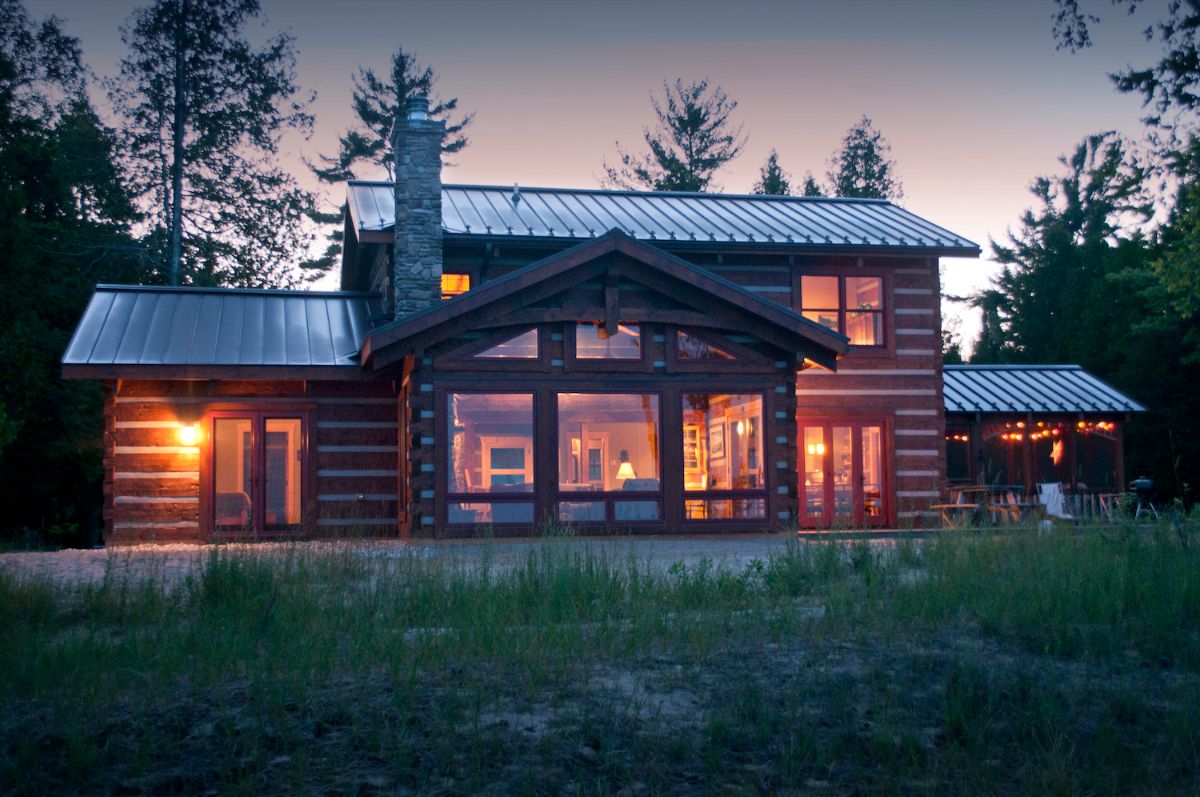 log cabin with lights on inside after dark