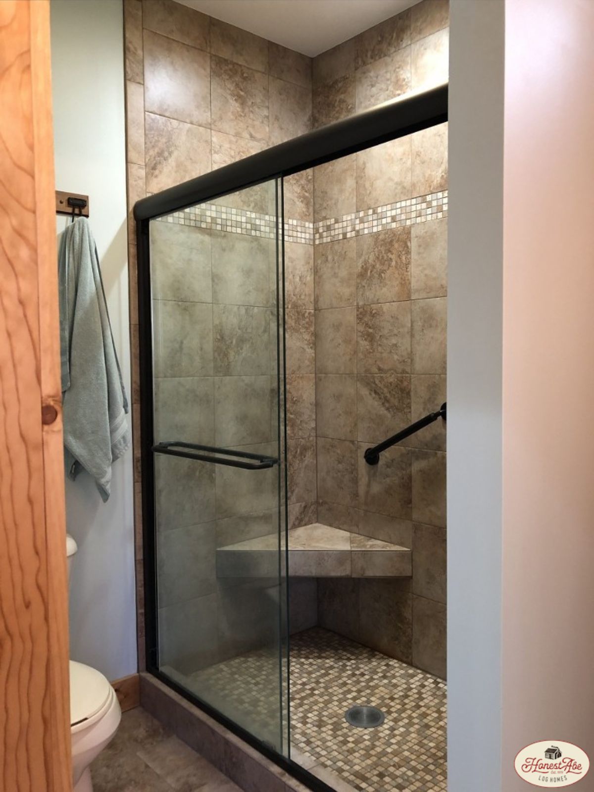 gray tiled shower with black grim around glass door