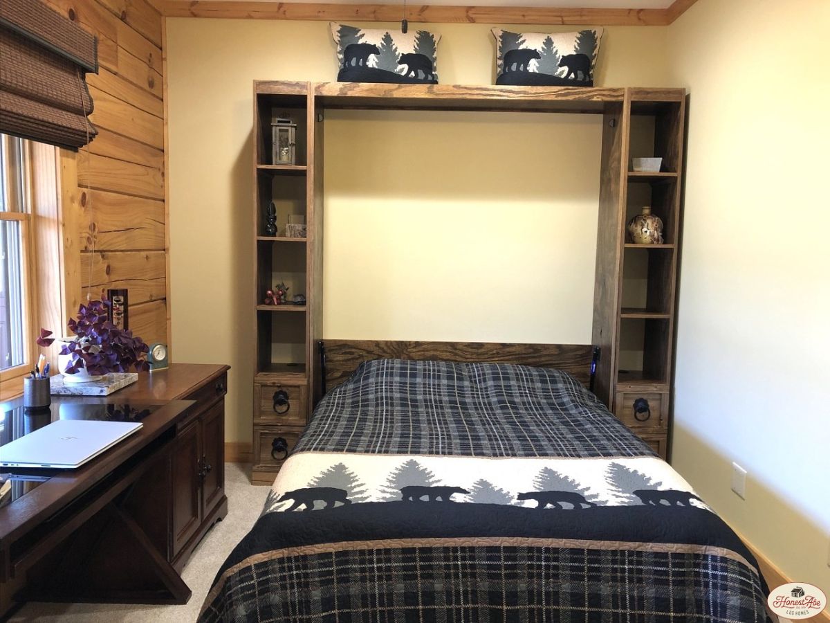 dark linens on bed with shelves on side and above