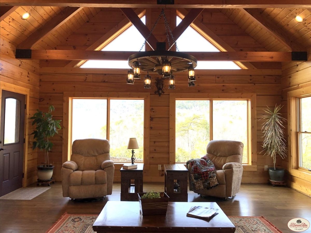 two cream recliners against glass doors in great room with chandelier above table