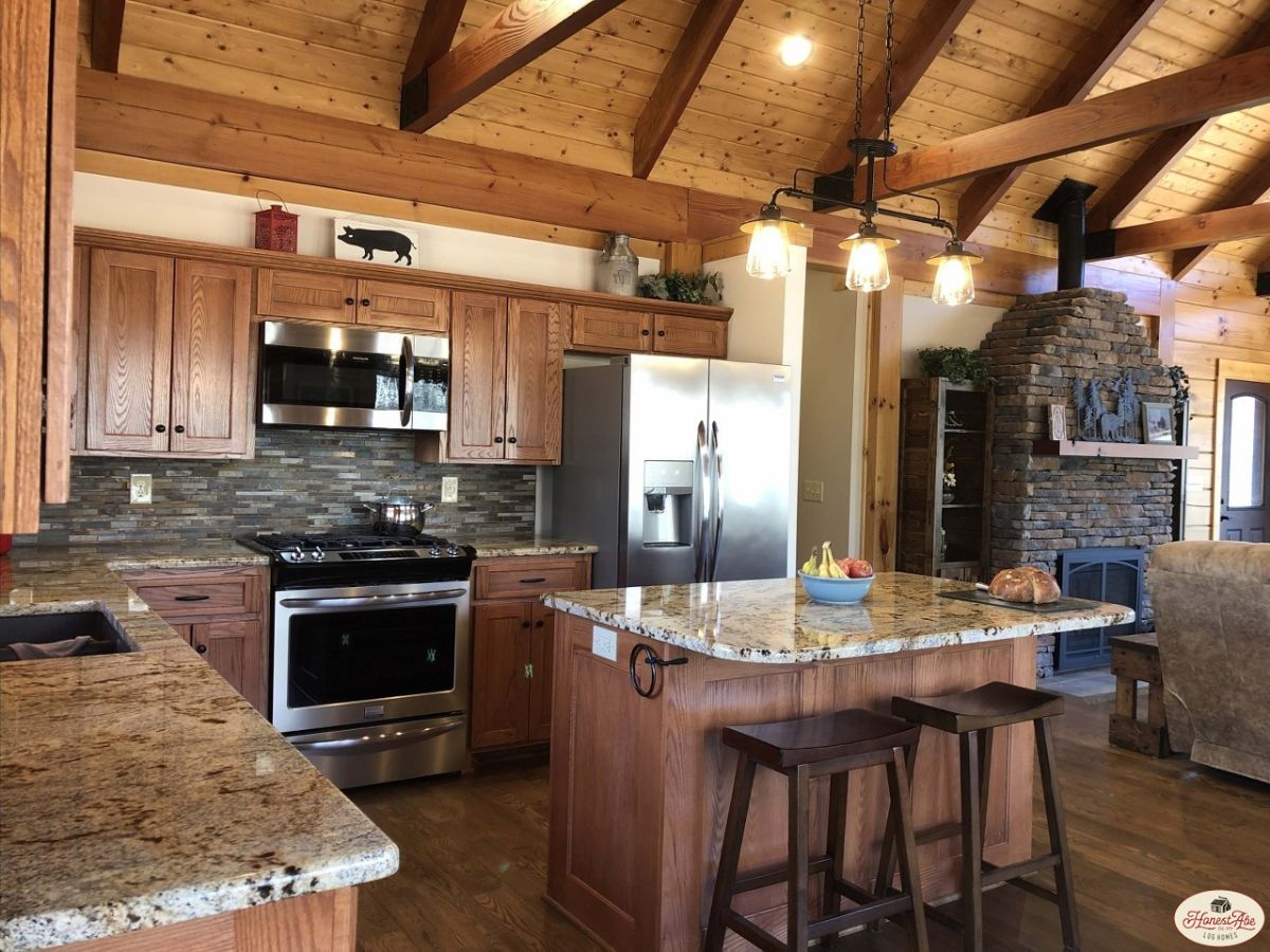 dark wood backless stools against island bar in kitchen with stainless steel appliances