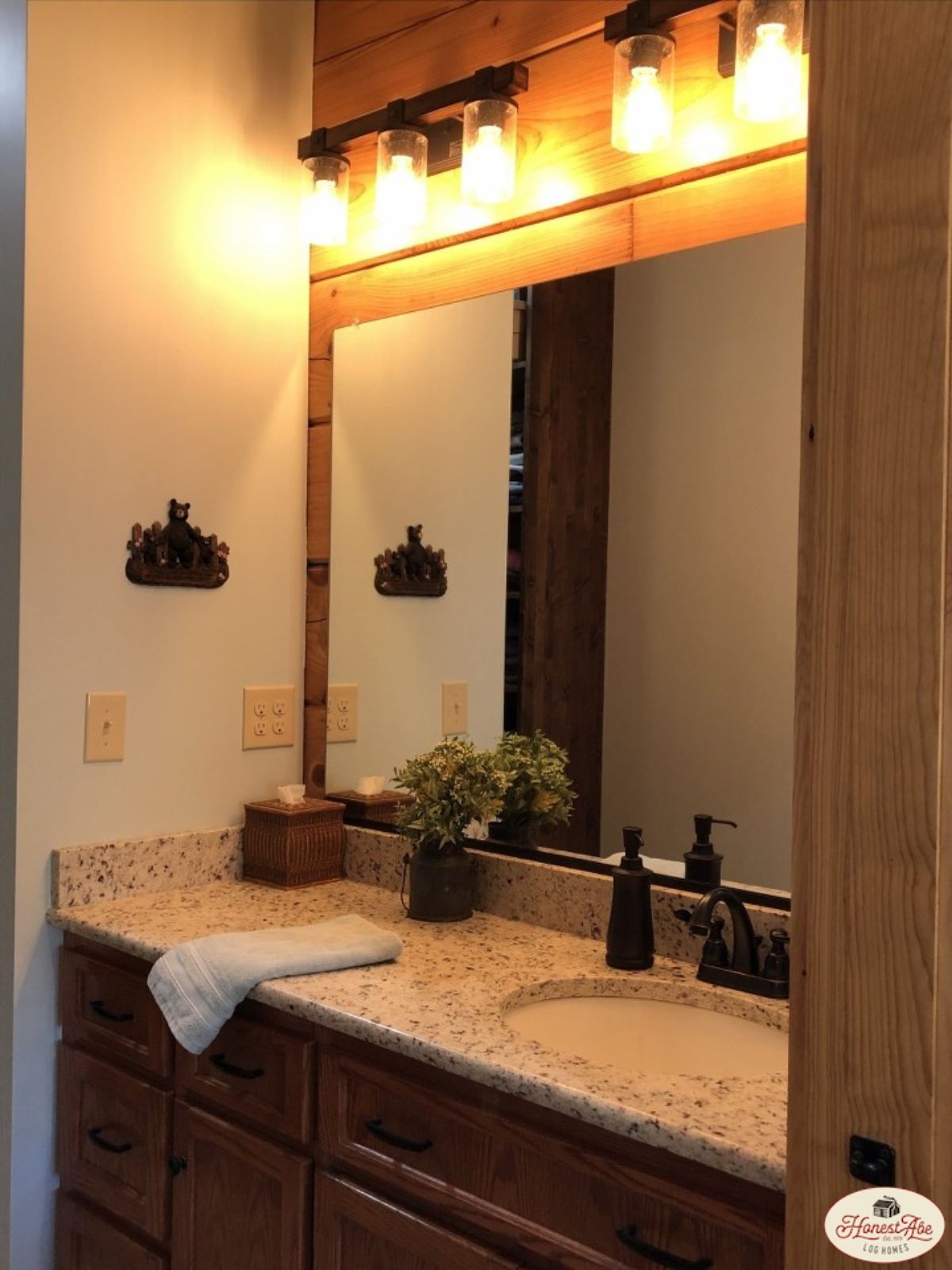 dark wood cabinets with light granite counter with mirror above counter