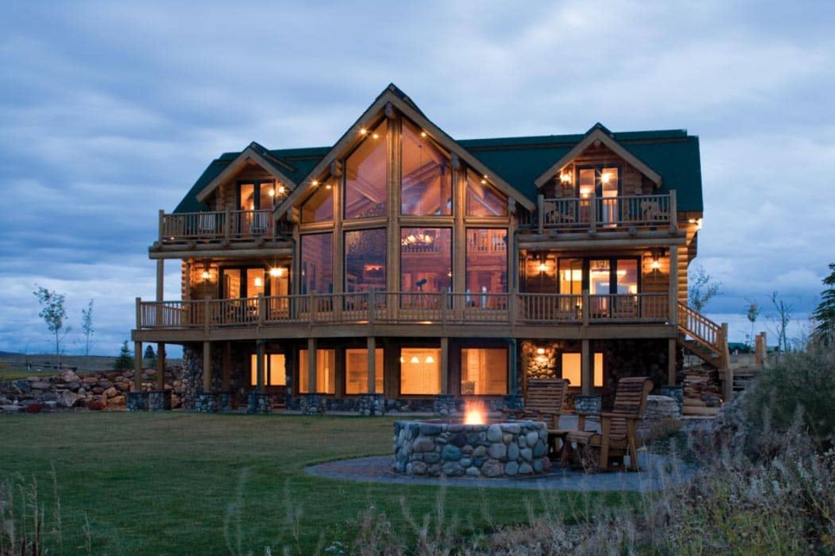 back decks of log cabin lit up after sunset