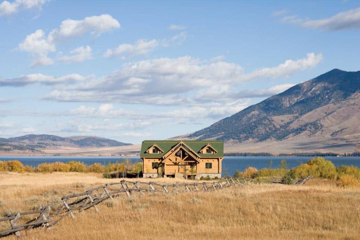 cabin on hill overlooking lake and mountain in background