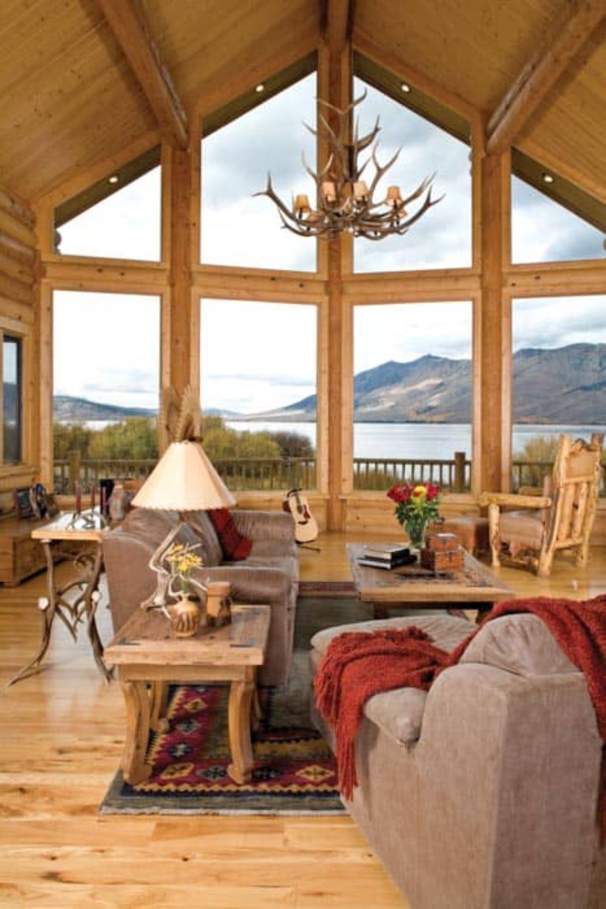 great room wall of windows overlooking water outside home