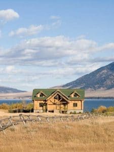 cabin on hill overlooking lake and mountain in background