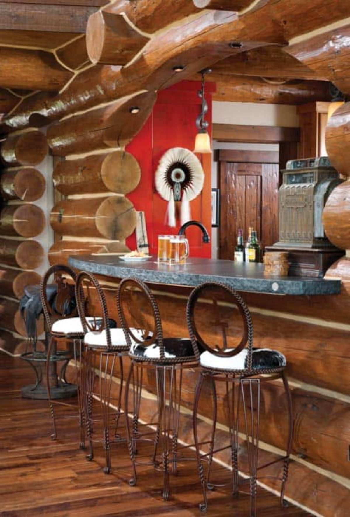 round back wood stools by bar in kitchen with red accent wall