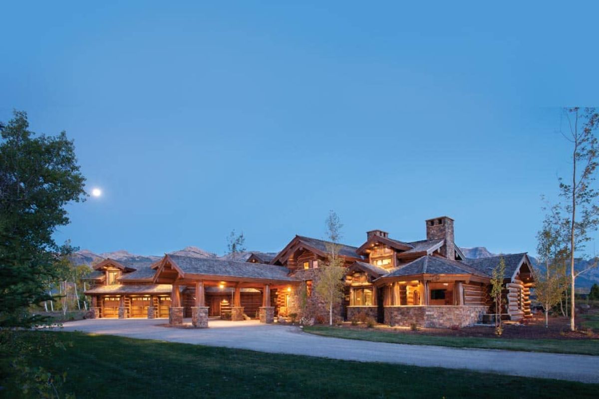 concrete drive with awning on front of log cabin