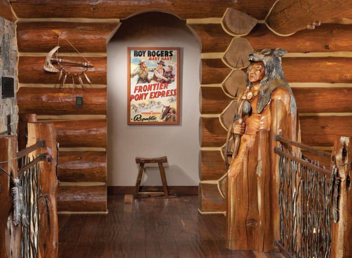 archway with picture and stool in background and wood native american carving in foreground