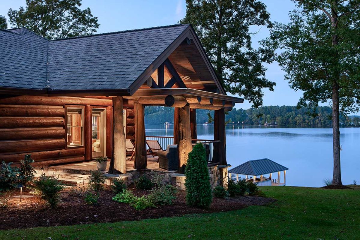 open deck on side of log cabin overlooking lake in background
