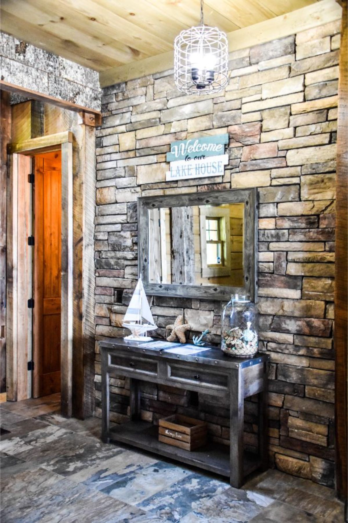 stone background behind mirror and side table in entry