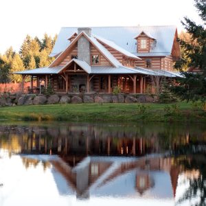 cabin with tin roof and porch overlooking pond