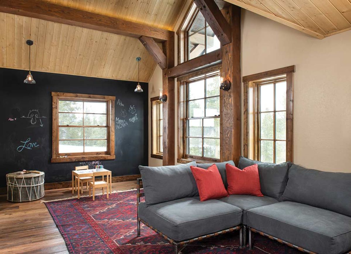 gray sofa on red rug in lofted space of cabin