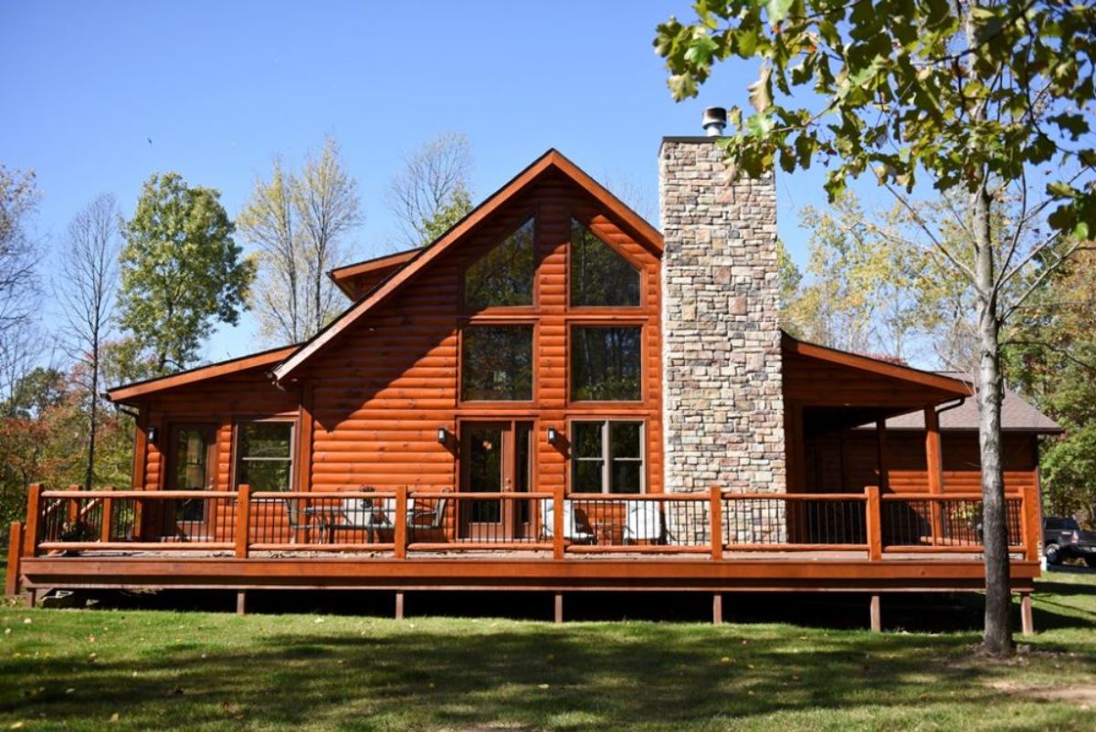 back open deck on log cabin with wall of windows