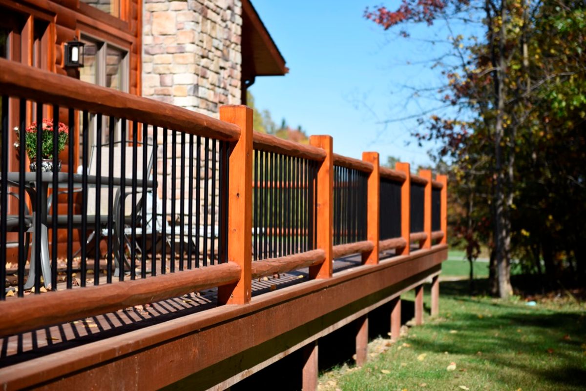 wood railing on open deck of log cabin