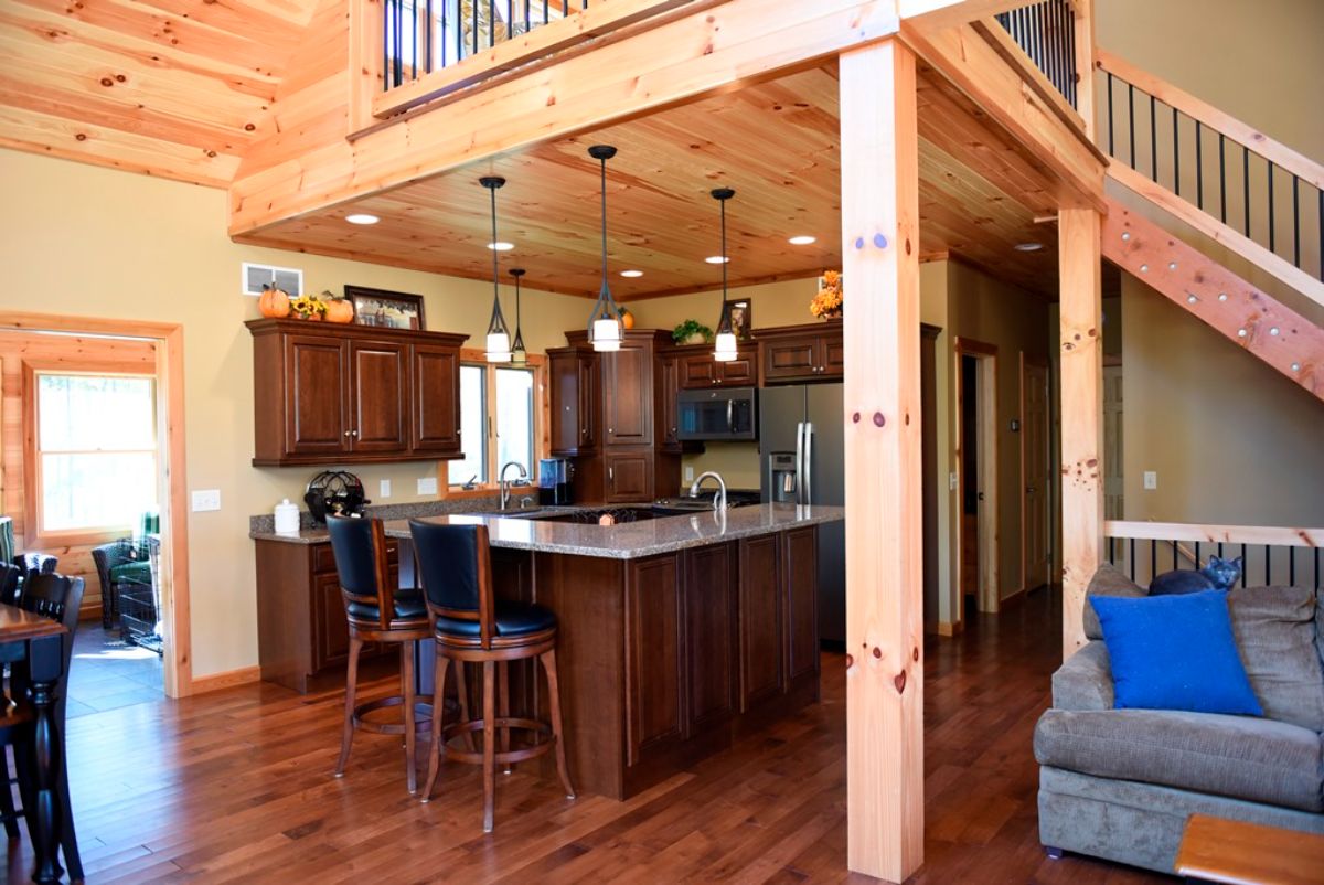 dark wood cabinets with light counter in kitchen under loft