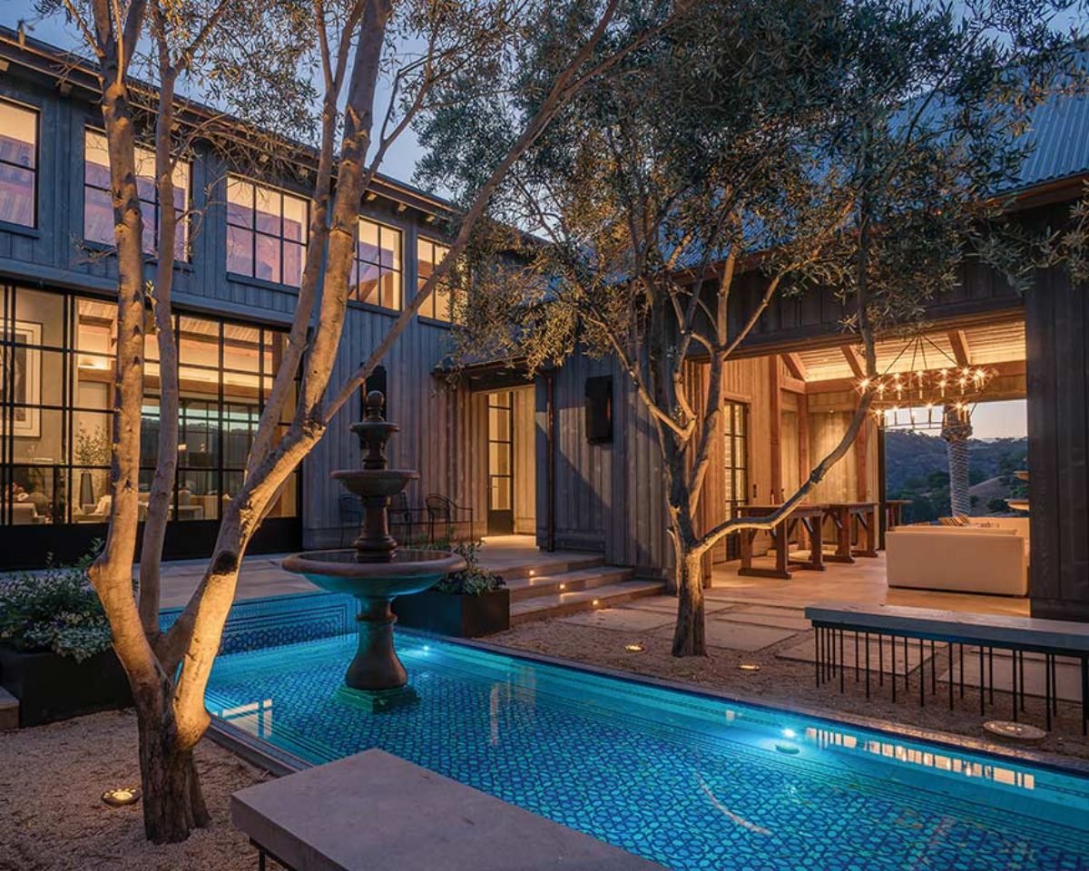 pool in foreground of courtyard with trees on both sides