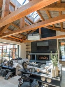 gray slate fireplace against back wall of living room with open beams above