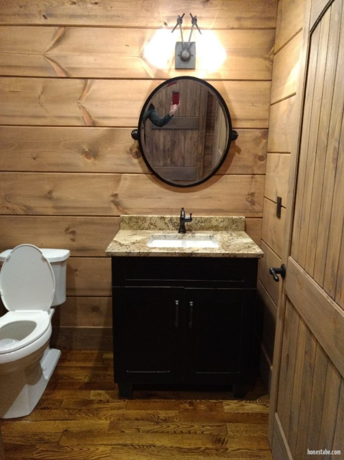 black vanity with white sink next to white toilet