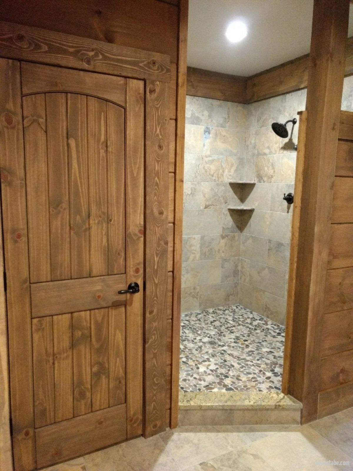 tiled shower in the corner of bathroom