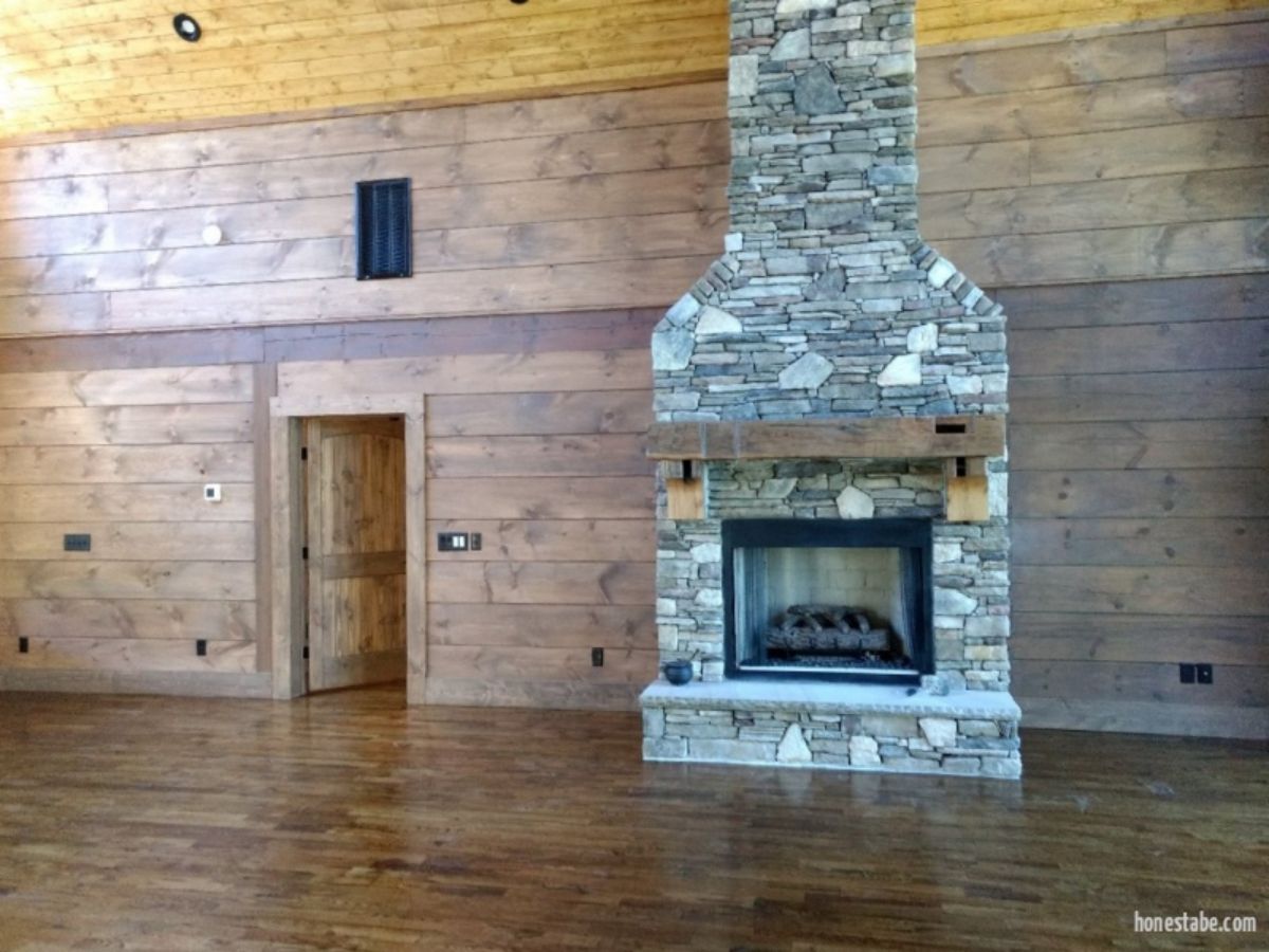 stone fireplace against wall of log cabin