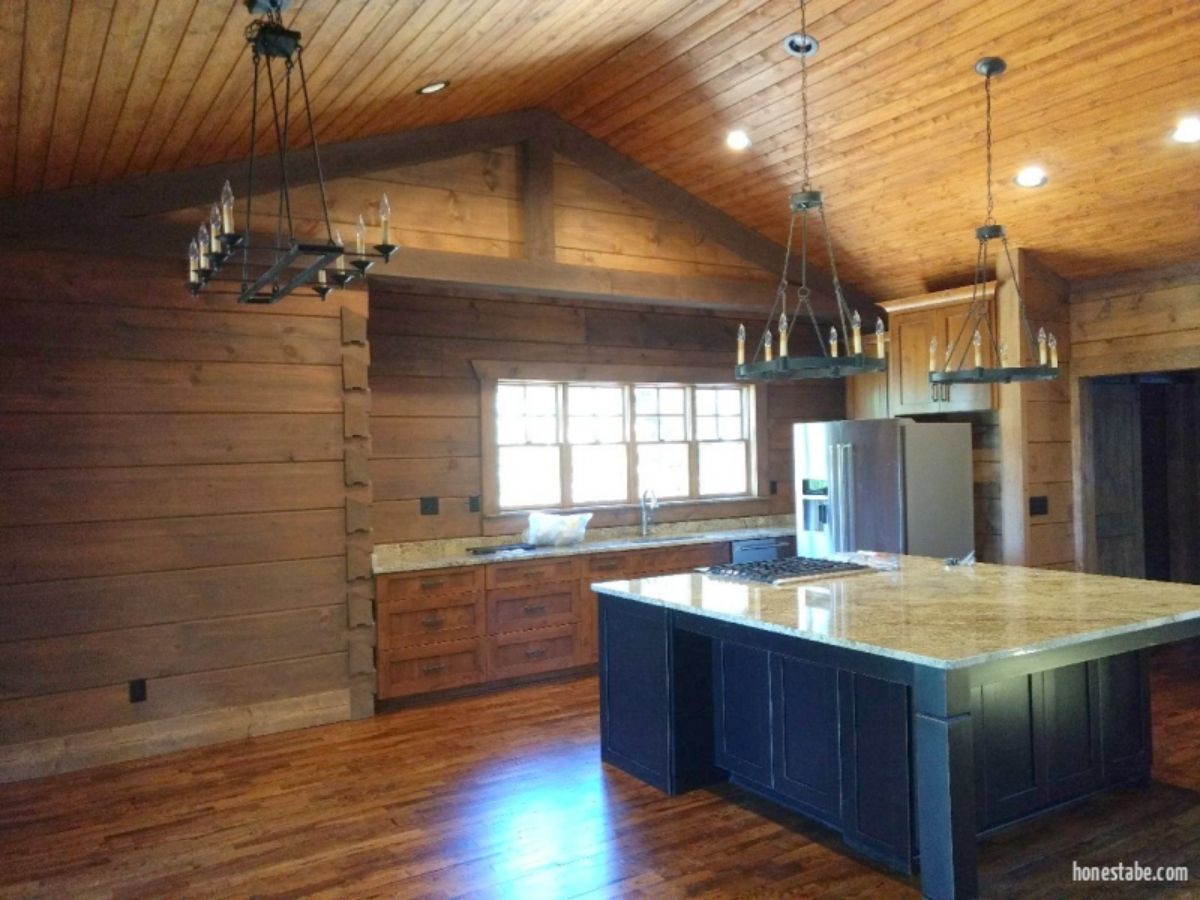 open kitchen with black cabinets under island with white top
