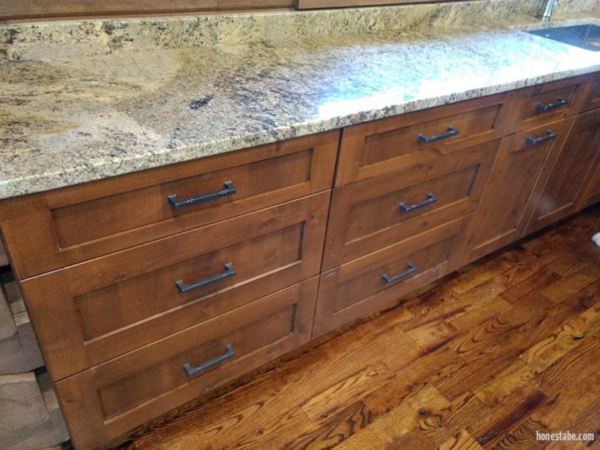 dark wood drawers under light granite countertop