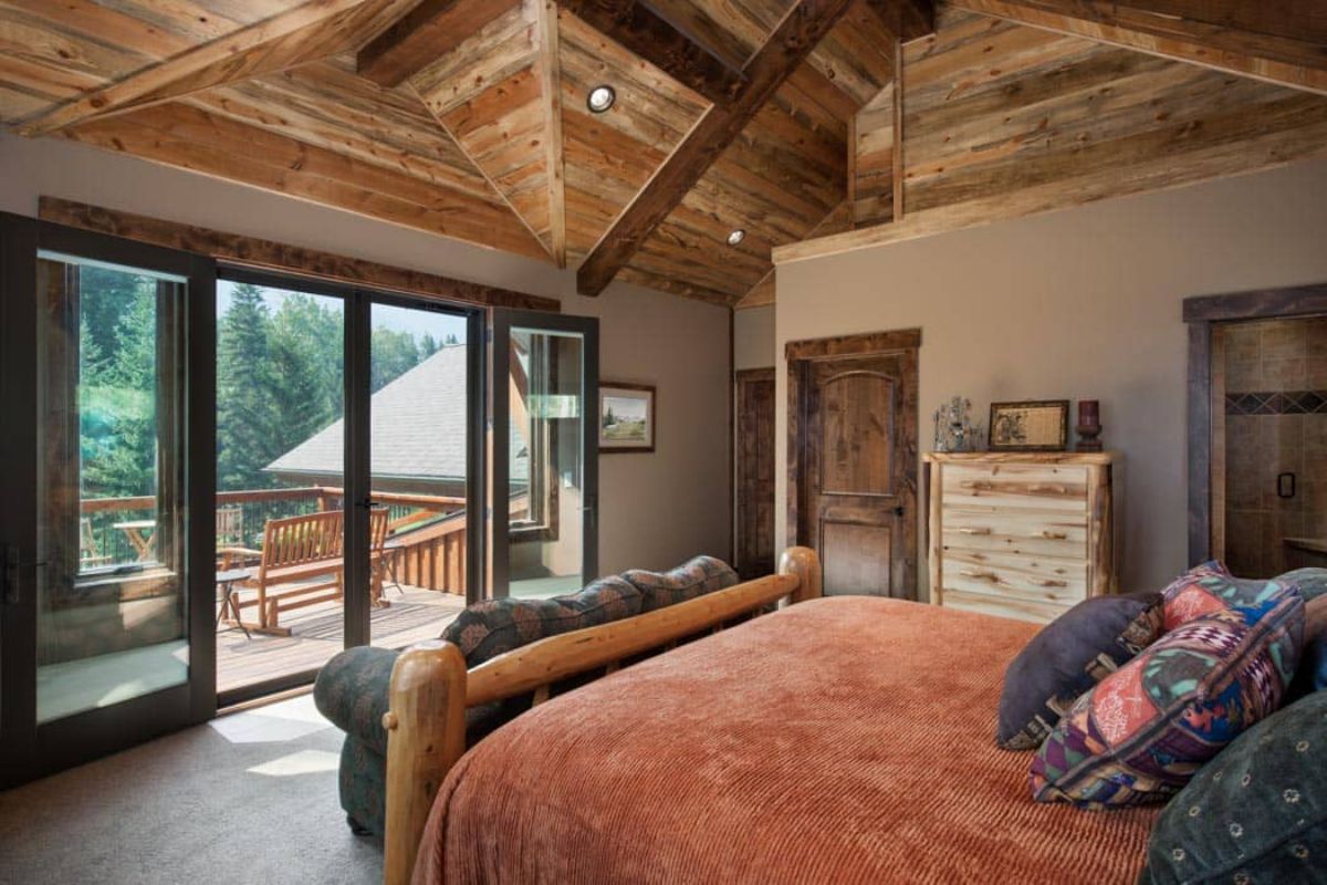 orange bedding on sofa in log cabin with patio door on left side