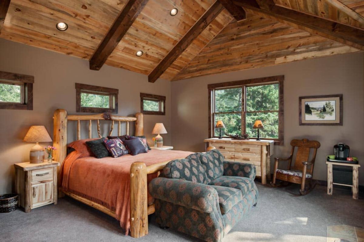 orange bedding with grey sofa at end of bed