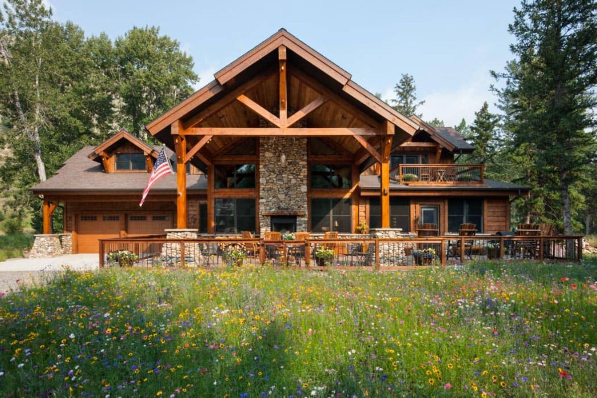 log cabin with stone fireplace in center of porch