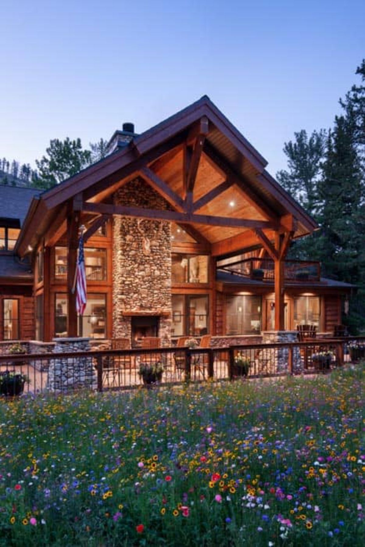 back of log cabin showing fireplace under awning