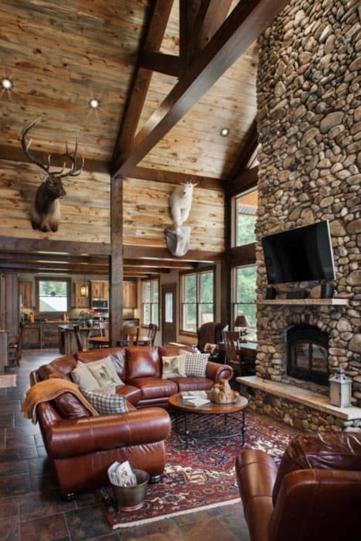 stone fireplace onr ight of image with brown leather sofa in front