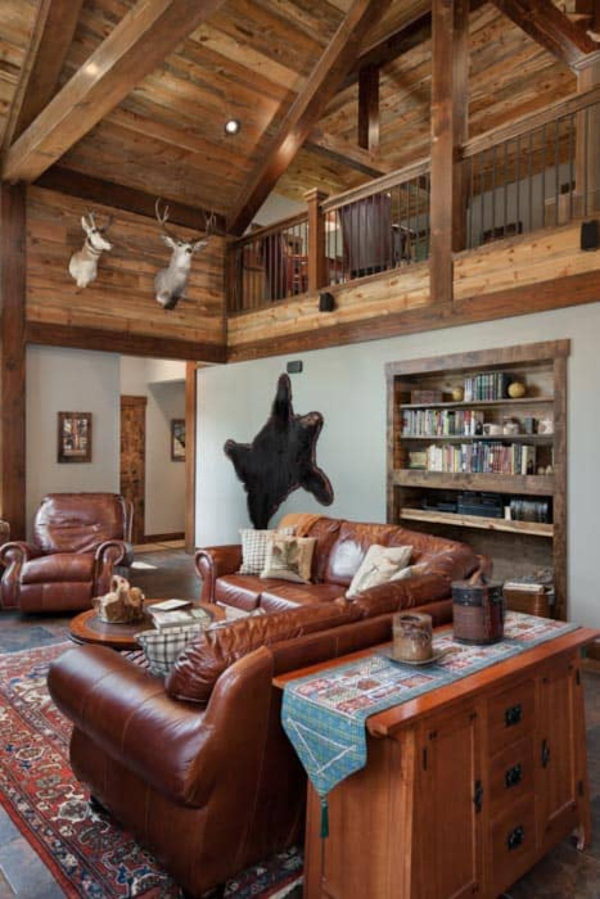 brown leather sofas in living room with bookcase on wall on right