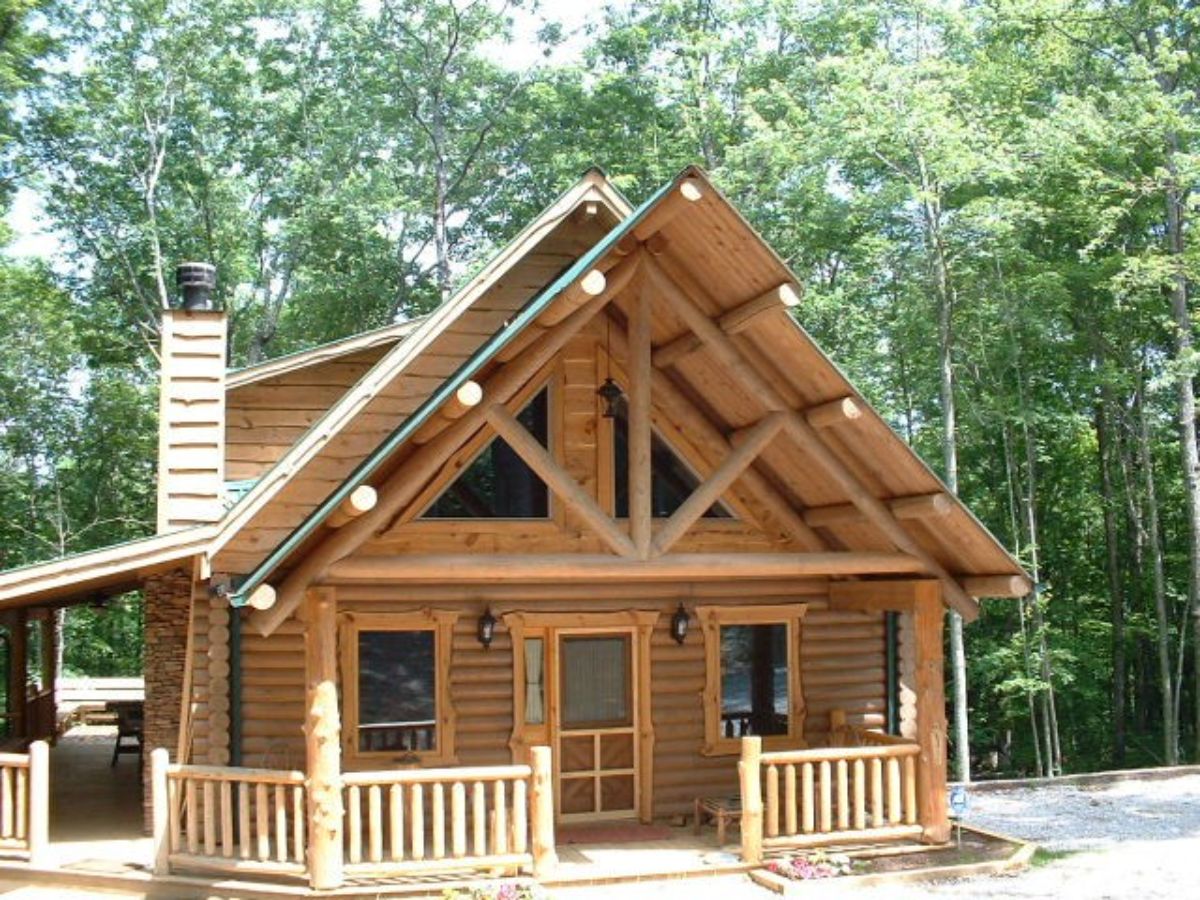 front of log cabin with light wood and lightly covered porch
