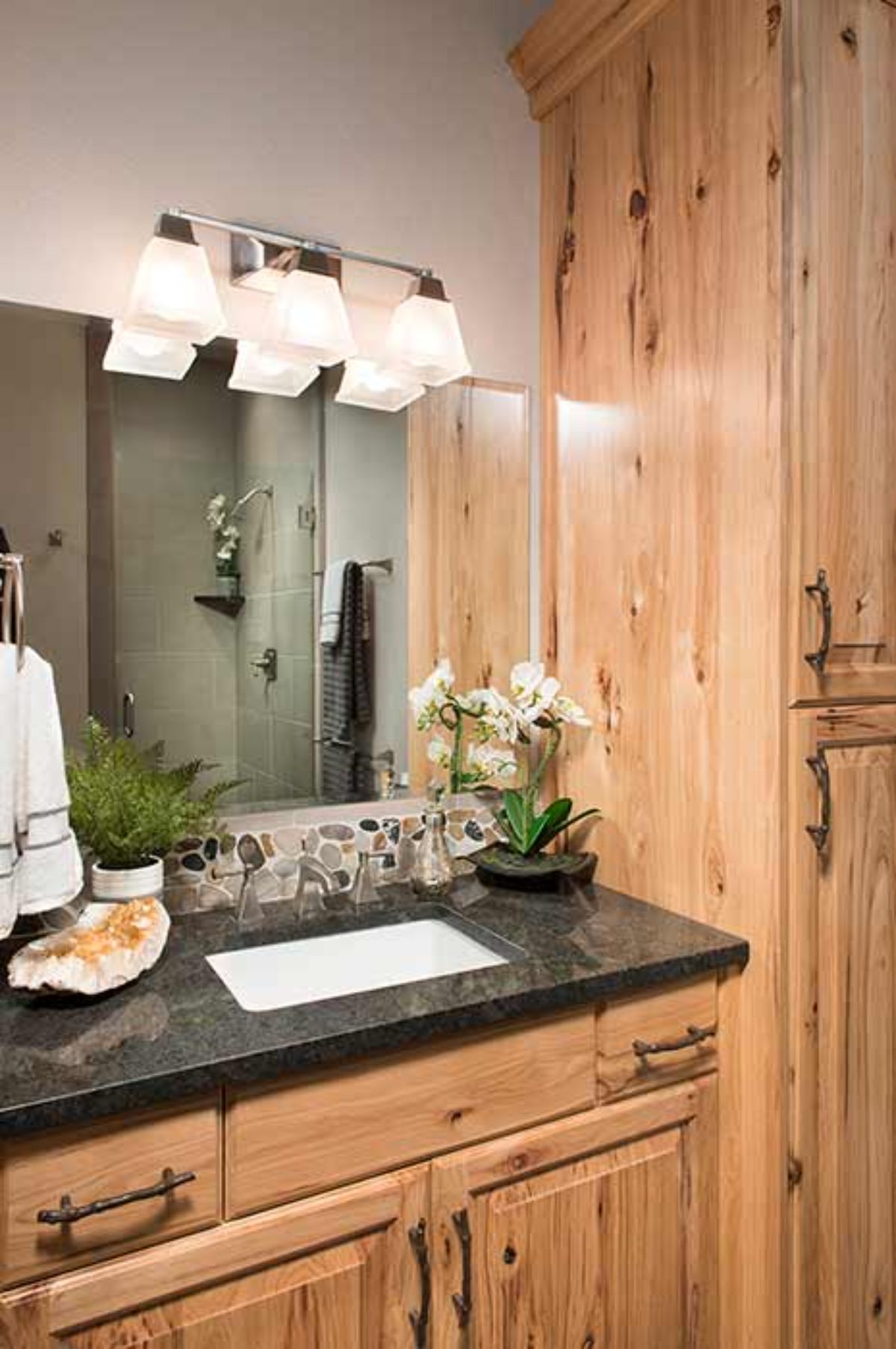 black countertop on light wood cabinets in bathroom