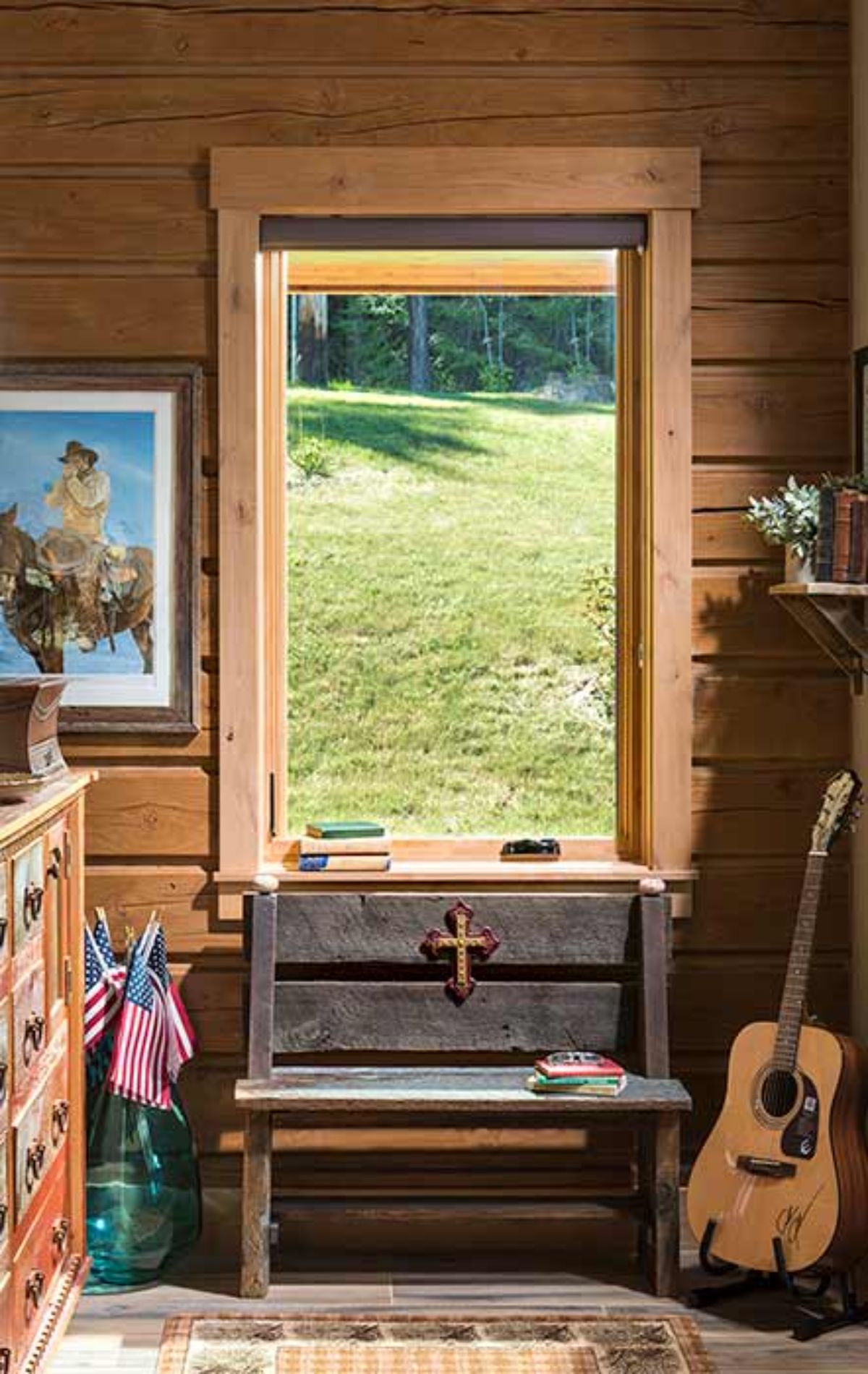 bench under tall window inside log cabin