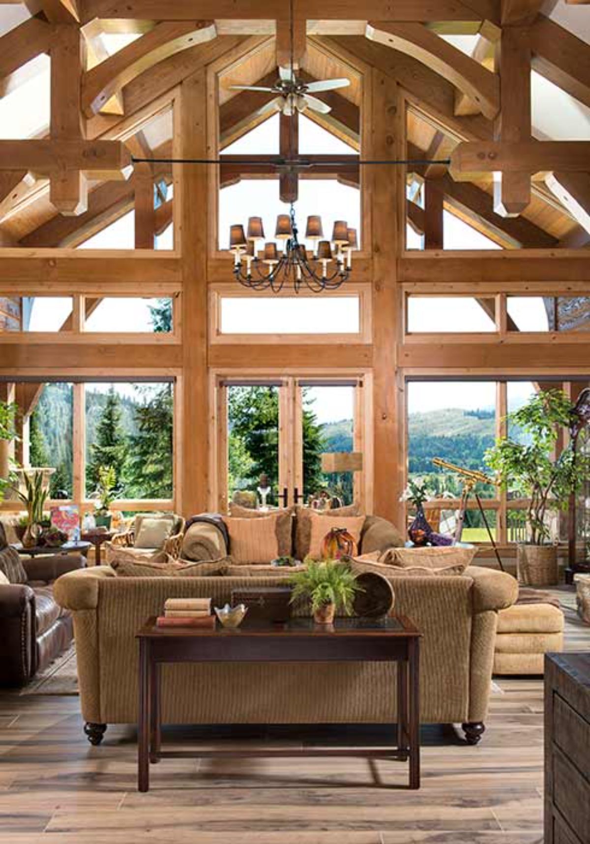 view across the back of brown sofa to the wall of windows overlooking mountains