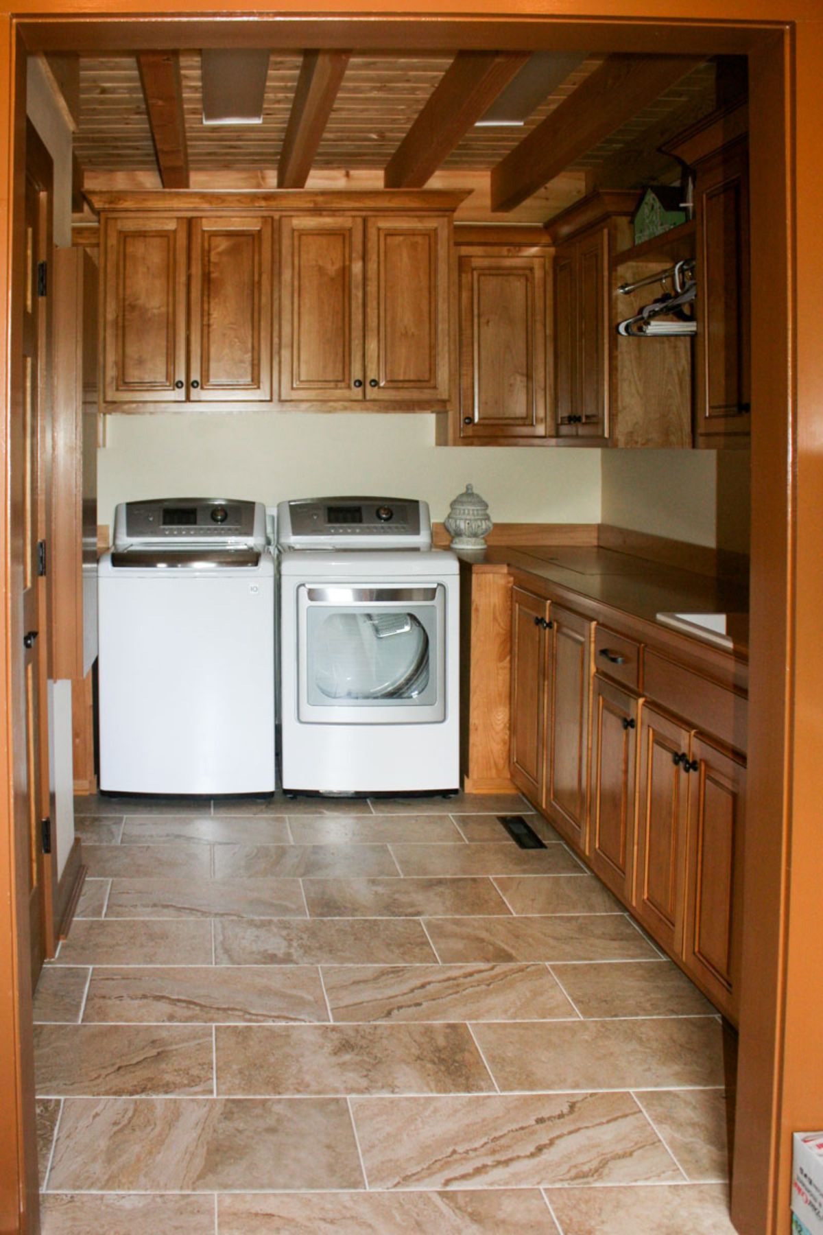 white washer and dryer against back wall with cabinets around edge of laundry room