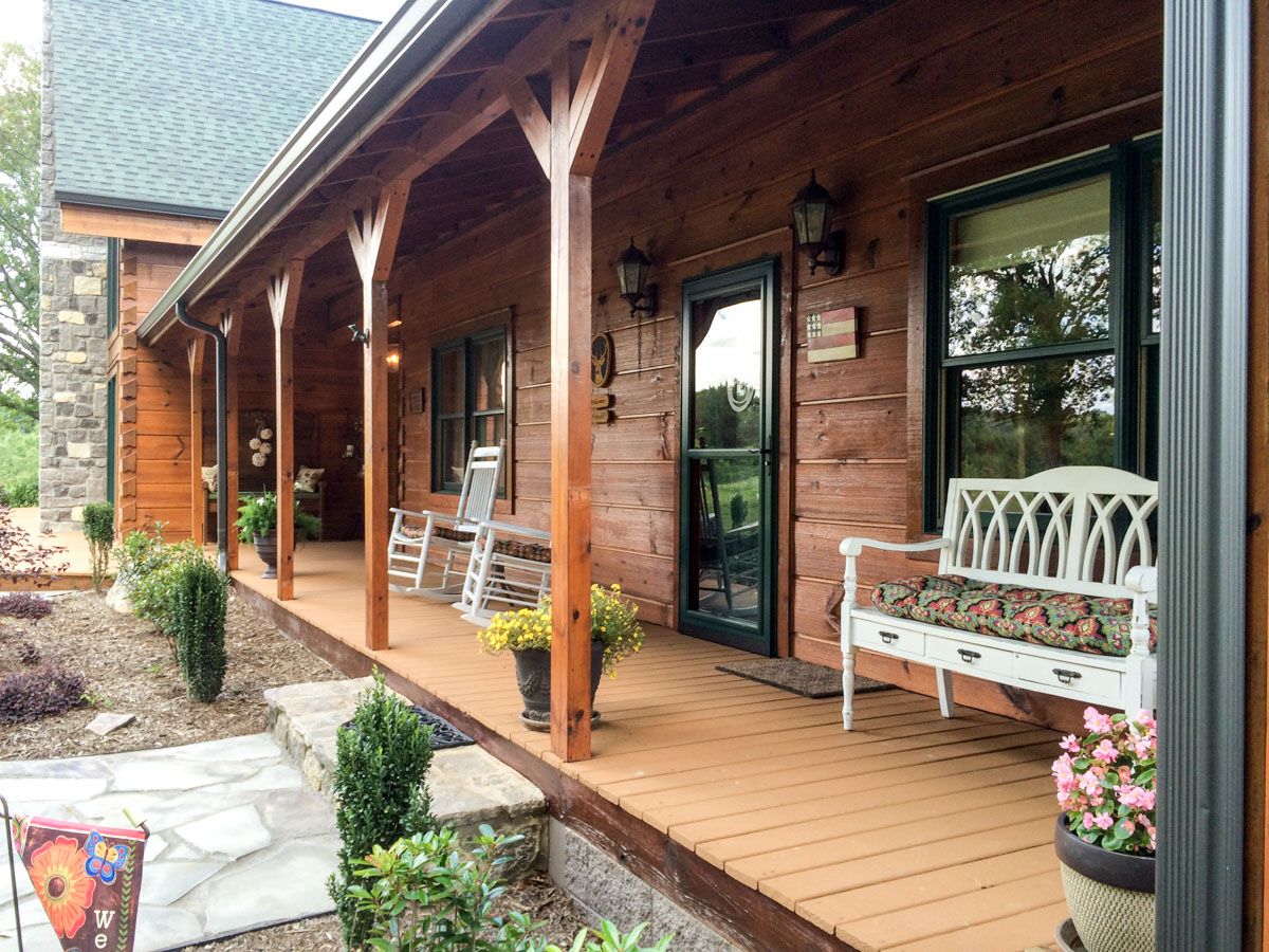 front porch of log cabin with white bench by door